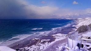 A coastal landscape with a beach, snow-covered areas, and a clear sky. - 1 Bed in Torpoint (oc-74824) (Millbrook)