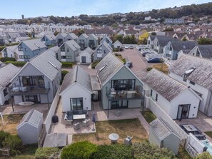 A residential area with multiple houses, each featuring a distinct architectural style, including gabled roofs and various window designs. - 4 Bed in Bideford (oc-75358) (Northam)