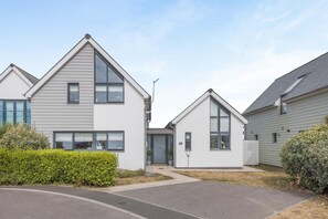 A residential building with a modern design, featuring a central entrance, a covered porch, and a small garden area. - 4 Bed in Bideford (oc-75358) (Northam)