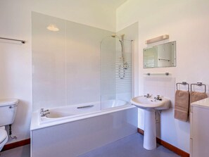 Een moderne badkamer met een bad, een wastafel en een toilet.