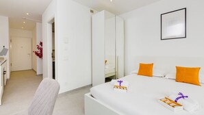 Et moderne hotelværelse med seng, sengebord og skrivebord.