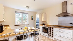 A modern kitchen with a wooden countertop, stainless steel appliances, and a large window. - 6 Bed in Lairg (oc-ca210) (Laxford Bridge)