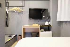 A hotel room with a bed, a desk with a kettle, a TV, and a coat rack. - LUMA URBAN HOTEL TAKADANOBABA (Tokyo)
