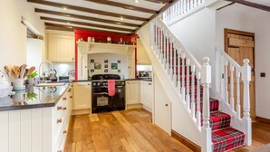 A kitchen with wooden beams, a red backsplash, and a staircase with red plaid steps. - 2 Bed in Drumnadrochit (oc-ca315) (Strone)