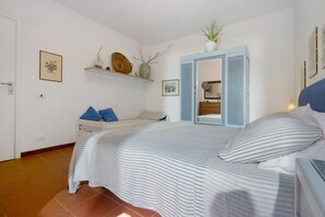 Ein Schlafzimmer mit einem Bett, einem Nachttisch, einem Spiegel und einem Regal mit Dekoration.