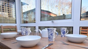 Uma mesa de jantar com louças brancas e azuis estampadas, uma faca e um garfo.
