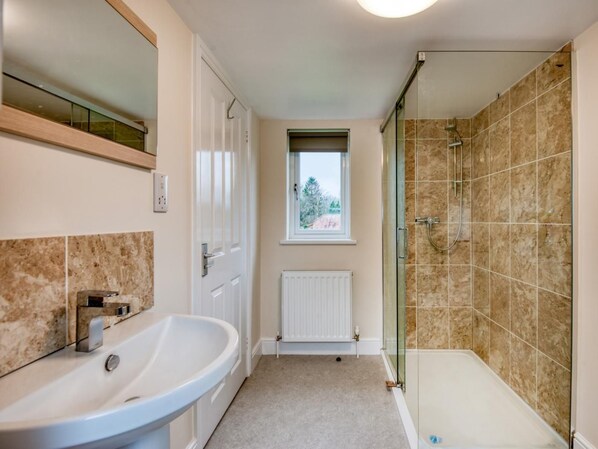Un baño con bañera, ducha y ventana.