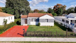 A residential area with houses, a red driveway, and a fenced yard. - 1935 NW 42nd St. (Miami)