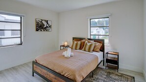 A bedroom with a bed, bedside tables, a lamp, a window, and a ceiling light. - 1935 NW 42nd St. (Miami)