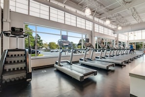 A gym with multiple treadmills, a stair climber, and large windows with a view of the outside. - Sea Colony - 55110 Manor Pl. (Bethany Beach)