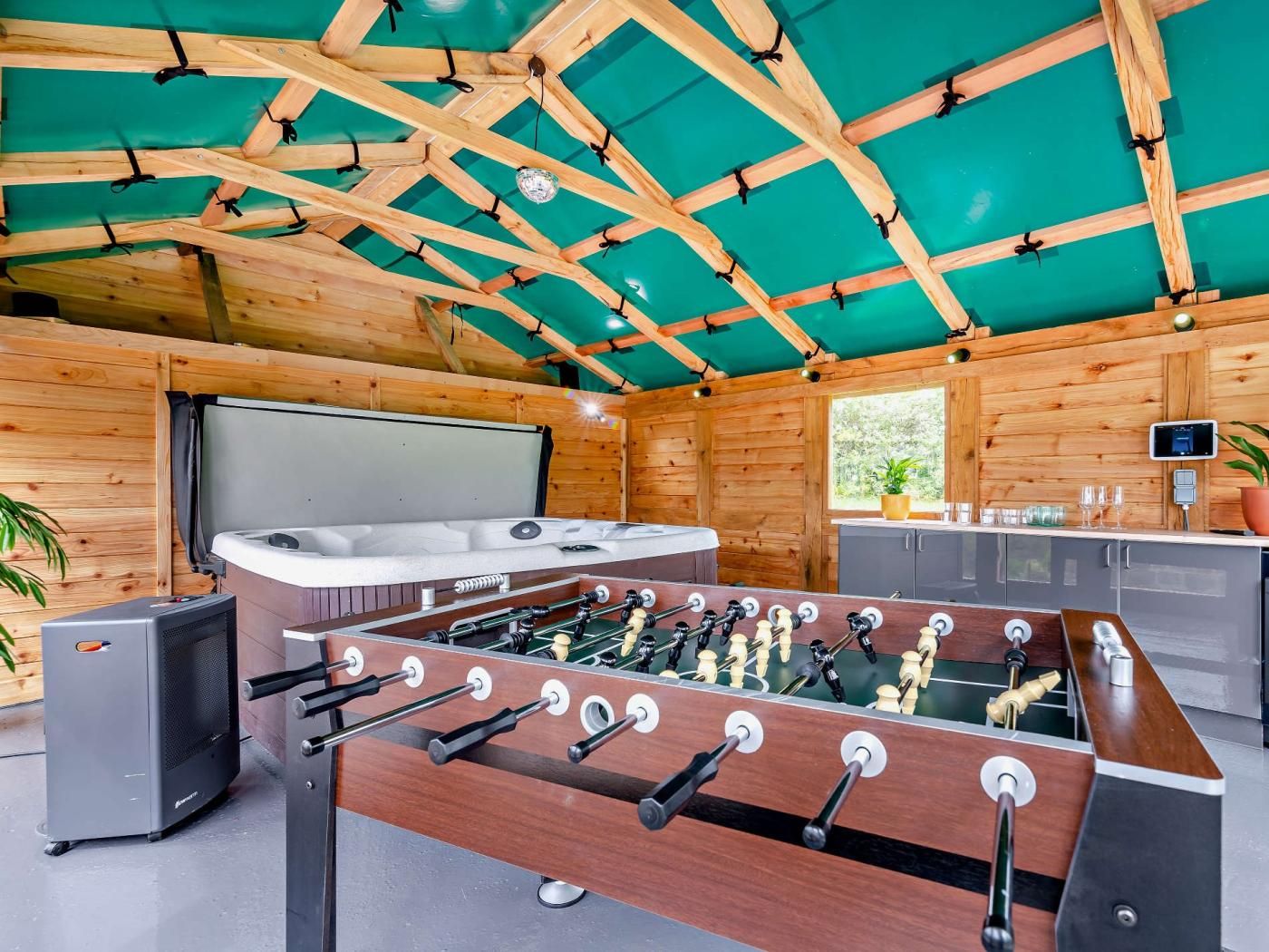 Ein Zimmer mit Kicker, Sauna und Fernseher.