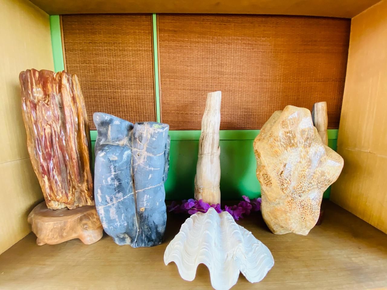 A collection of stone sculptures on a wooden shelf.