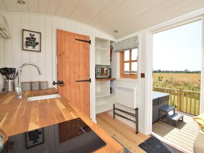 A kitchen with a wooden door, a window, and a view of the outdoors. - 1 Bed in Market Rasen (oc-83847) (Faldingworth)