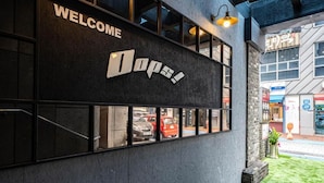 A building with a 'WELCOME' sign and a large 'Oops!' sign on the facade.