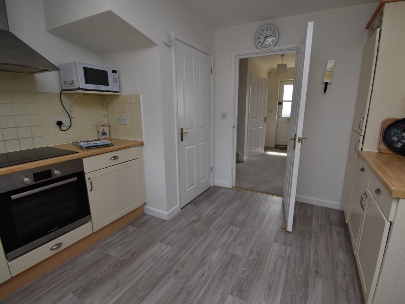 A kitchen with a microwave, oven, and wooden countertop.