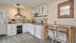 A kitchen with white cabinets, a gas stove, a microwave, and a sink. - 2 Bed in Cockermouth (oc-sz431) (Wythop)