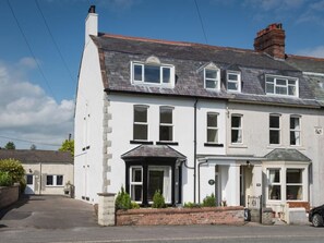 A two-story building with a white facade, multiple windows, and a brick chimney. - 2 Bed in Cockermouth (oc-sz431) (Wythop)
