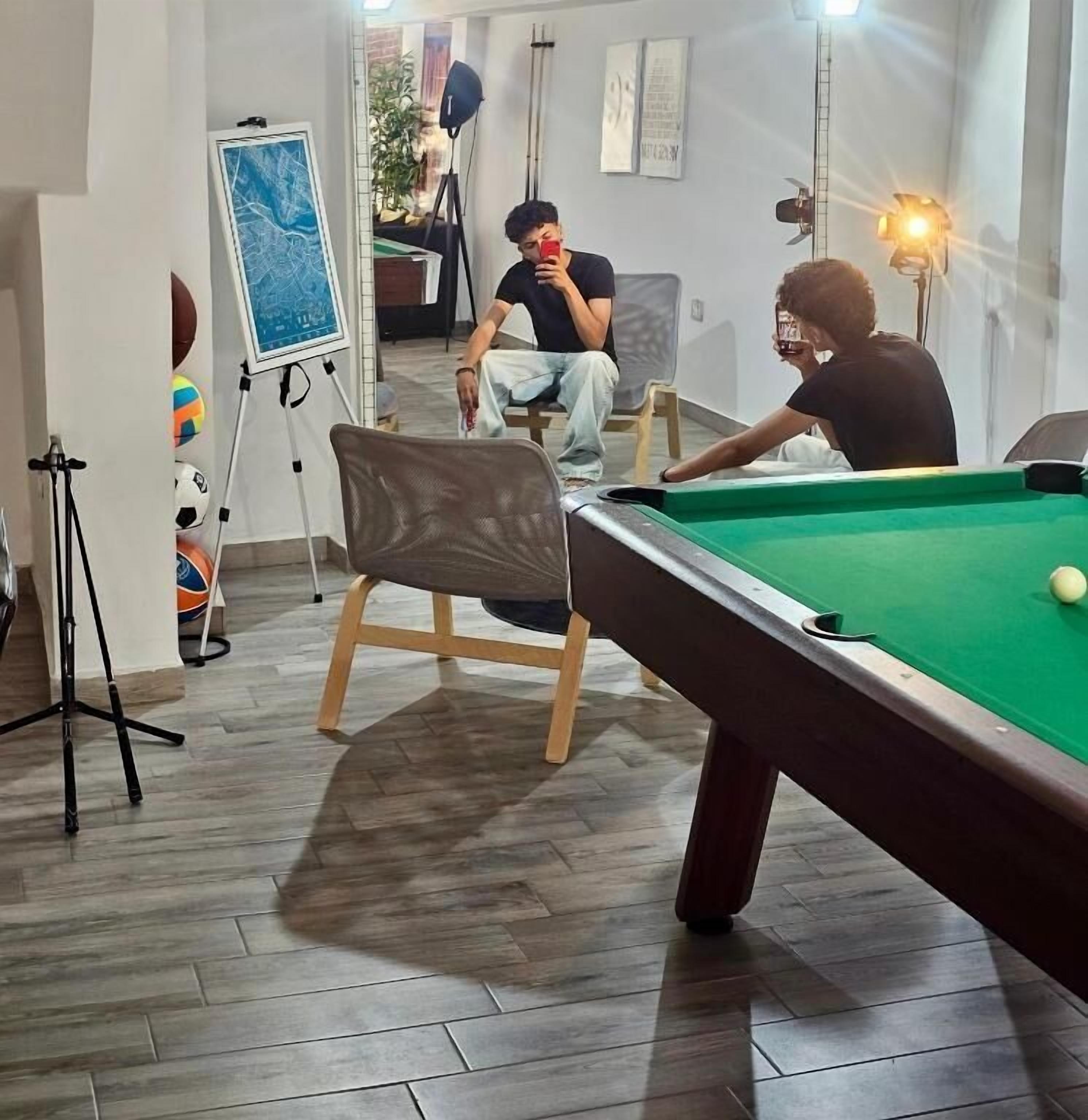 A pool table in a room with a tripod and a map stand.