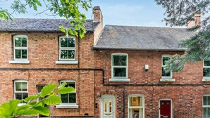 A two-story brick building with white-framed windows and doors, a red door, and a chimney. - 2 Bed in Ashbourne (oc-85571) (Ashbourne)