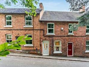 A two-story brick building with white-framed windows and doors, a red door, and a chimney. - 2 Bed in Ashbourne (oc-85571) (Ashbourne)
