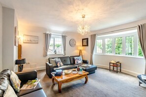 A living room with a sofa, coffee table, and a chandelier. - 1 Bed in Filey (oc-77710) (Hunmanby)