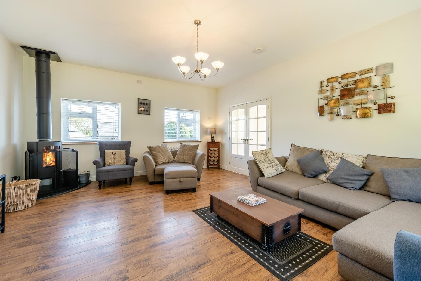 A spacious living room with a fireplace, sofas, a coffee table, and a decorative wall piece.