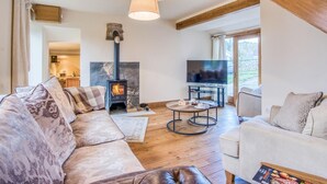 A cozy living room with a fireplace, a television, and a staircase. - 3 Bed in Buxton (oc-77739) (Hartington)