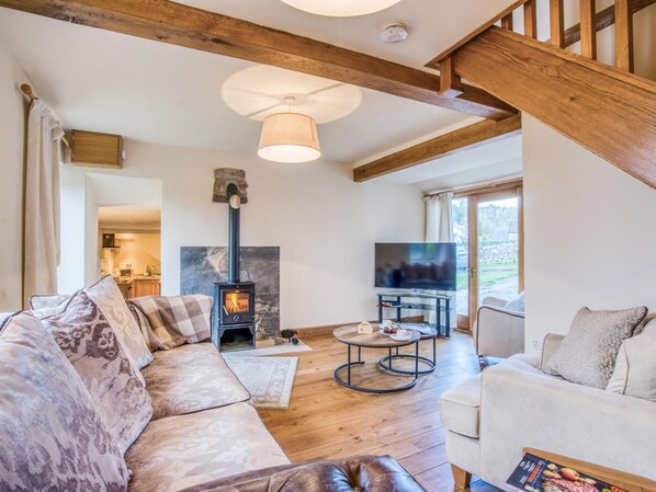A cozy living room with a fireplace, a television, and a staircase. - 3 Bed in Buxton (oc-77739) (Hartington)