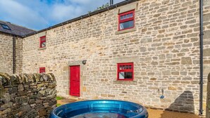 Un bâtiment en pierre avec un jacuzzi à l’avant.
