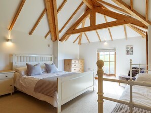 A bedroom with a white bed, wooden beams, a dresser, and a window with a view. - 3 Bed in Crackington Haven (oc-78271) (Crackington)