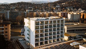 Un edificio moderno con una fachada de ventanas en cuadrícula y techo plano.