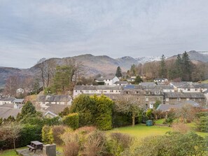 Ein Dorf an einem Hang mit traditionellen Steinhäusern, einem Picknicktisch und Blick auf die Berge.