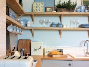 A kitchen with wooden shelves, a toaster, a bread sign, and a basket of bread. - 2 Bed in Ventnor (oc-75920) (Ventnor)
