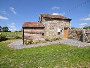 A stone building with a wooden door and a small attached shed. - 2 Bed in Bristol (oc-75697) (Bristol)