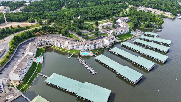 Eine Luftaufnahme eines Hotelkomplexes mit mehreren Gebäuden, einer Marina und einem großen Wasserabschnitt.