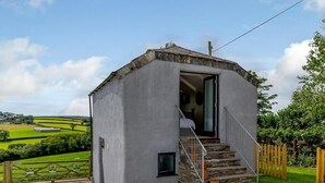 A small, single-story building with a stone staircase leading to a door. - 1 Bed in Launceston (oc-78428) (Boyton)