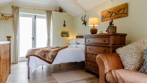 A bedroom with a bed, wooden dresser, and a chair. - 1 Bed in Launceston (oc-78428) (Boyton)