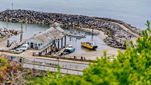 A coastal fishing port with a pier, boats, and a small building labeled 'Venture Bay Fishing.' - 3 Bed in Ventnor (oc-80547) (Ventnor)