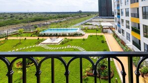 Un edificio residencial con piscina, jardín y vistas del paisaje circundante.