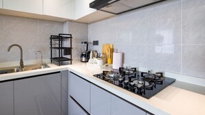 Una cocina moderna con estufa a gas, cafetera y pileta.