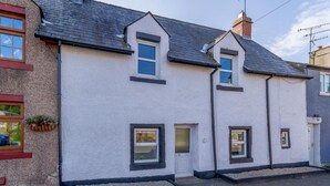 A two-story house with a white exterior, a dark roof, and a small front door. - 2 Bed in Kirkby Thore (oc-78744) (Kirkby Thore)