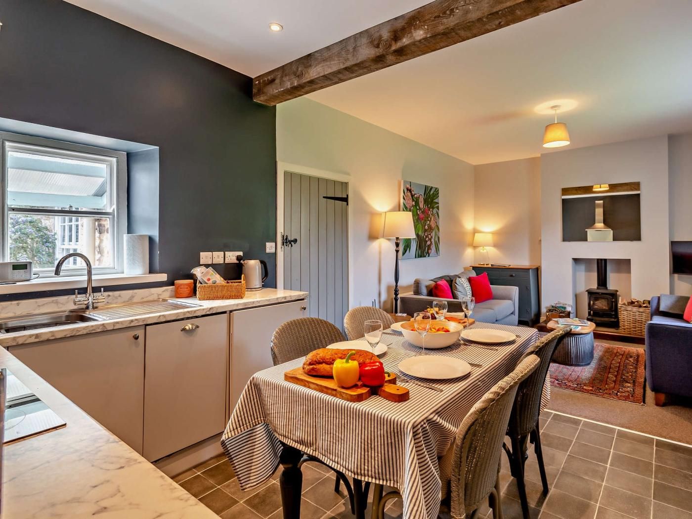 A modern kitchen with a dining area, a fireplace, and a window.