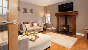 A living room with a sofa, a fireplace, a television, and a window. - 2 Bed in Stokesley (oc-g0072) (Great Busby)