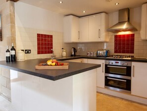 A modern kitchen with white cabinets, a granite countertop, a built-in oven, a gas stove, and red-tiled backsplash. - 3 Bed in Chopgate (oc-g0110) (Chop Gate)