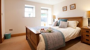 Une chambre à coucher avec un lit en bois, des tables de chevet, une fenêtre et une lampe.
