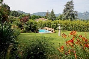 A residential property with a swimming pool, lush greenery, and a mountainous backdrop. - Guest Room in Family Home – The Engraving Room at the Foot of the Monts d'Ardèche (Jaujac)