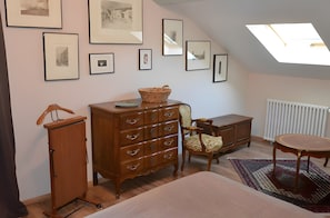 A room with a bed, dresser, chair, table, and framed pictures on the wall. - Guest Room in Family Home – The Engraving Room at the Foot of the Monts d'Ardèche (Jaujac)