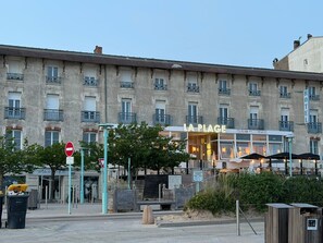 Ein Hotel mit einem Schild 'LA PLAGE' und einem Restaurant namens 'CUISINE DE PLAGE' im Erdgeschoss.