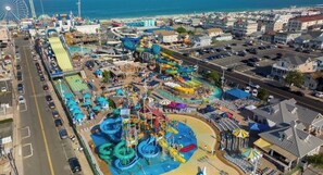 An aerial view of a coastal amusement park with water slides, a Ferris wheel, and a parking lot. - Spacious 5-bedroom house in Seaside Heights (Seaside Heights)