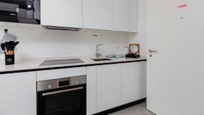 A modern kitchen with white cabinets, a Bosch microwave, a sink, and a dishwasher. - {Suite 410} Gym, Business Room, Modern, Relax (Lugano)